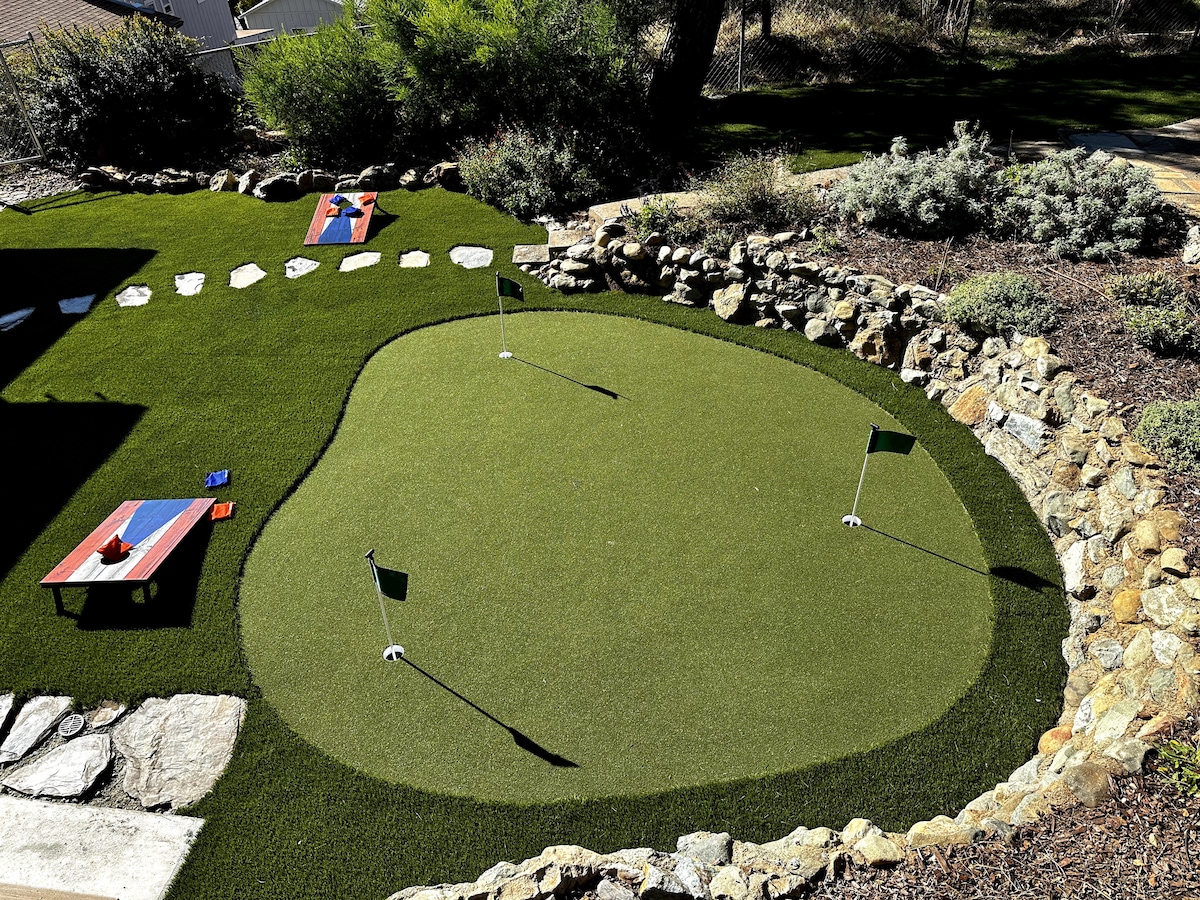 Welcoming back yard with corn hole game and brand new putting green!